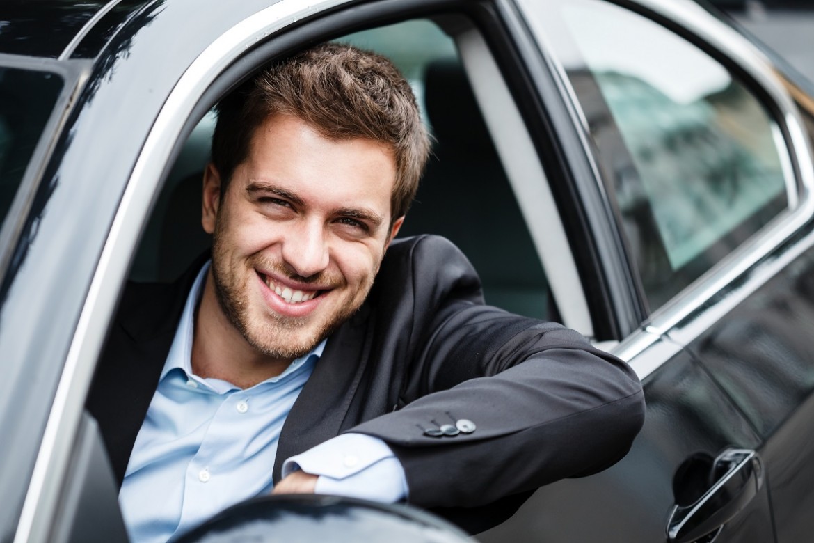 Mężczyzna w samochodzie z wypożyczalni aut korzystający z usługi car sharing